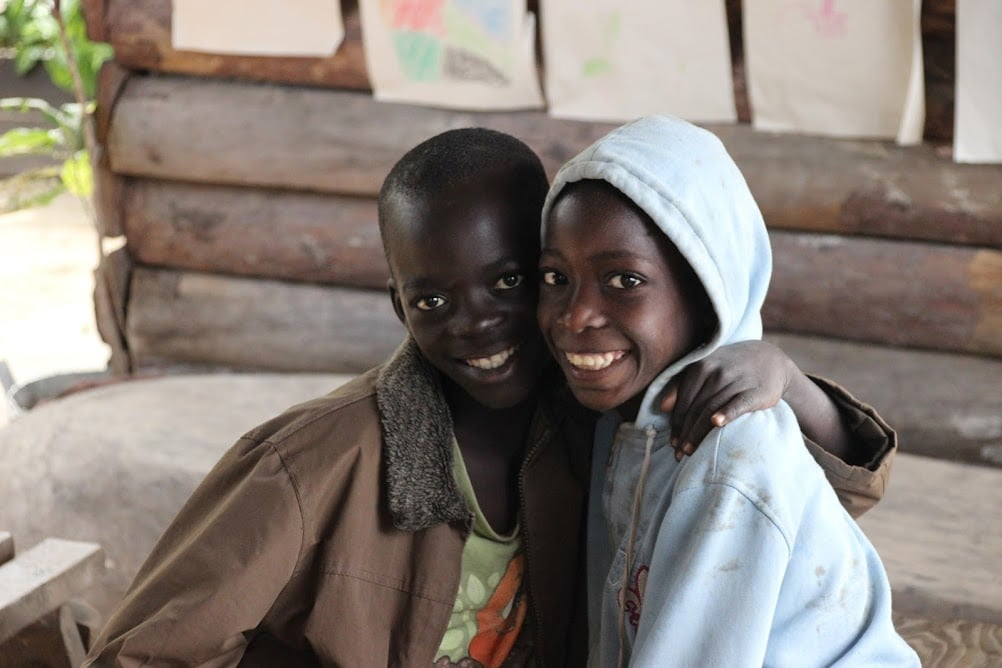 Two children hugging and smiling.